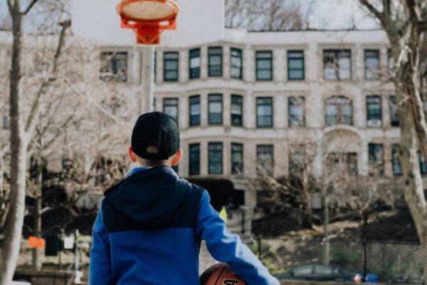 A young man looking at a basketball ring