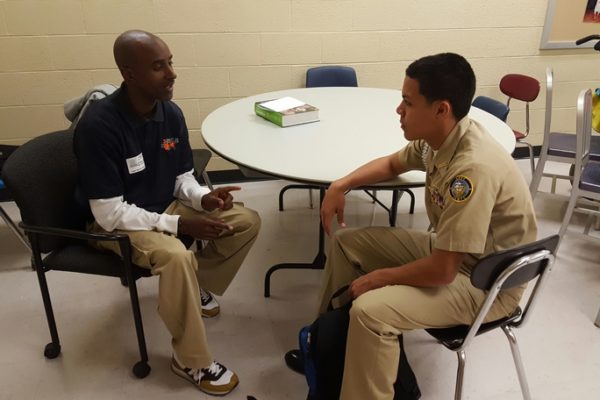 Picture of Gerald Jarmon talking with a young man in uniform